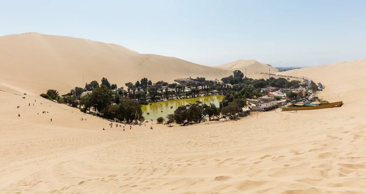 Huacachina oasis, Ica Region, Peru. The location has a population of 115 and is built around a natural lake in the desert and is a popular destination for sandboarding and buggy riding.