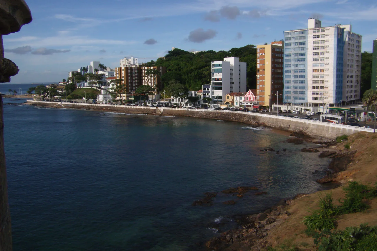 PT: A praia do Porto da Barra está situada no bairro da Barra, banhada pela Baía de Todos os Santos.
Localiza-se no bairro da Barra; limita-se ao sul pela encosta que é formada pela Ladeira da Barra, passando pelo Hospital Espanhol indo até o Farol da Barra, passando pela fortaleza de Santa Maria. (Fonte: Wikipédia)
EN: Porto da Barra Beach is located in the city of Salvador, Bahia. It is located at the entrance of the Bahia de Todos os Santos, with a small, white colonial fort at one end and a whitewashed church sitting up on a hill at the other. As the beach is in a bay, the water is calm (given that it is right in the heart of Brazil's third-largest city) . And in a country with over 7,000 km of east-facing coastline, the Porto is one of the few facing west, and sunsets can be seen from there. (By: Wikipedia)