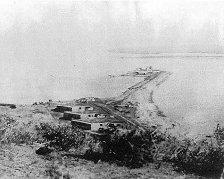 Ballast Point, near present-day San Diego, California. Description at source states: "Battery Wilkeson. This view depicts Battery Wilkeson and Fetterman overlooking the 1890 lighthouse and whaler’s warehouses at the eastern tip of Ballast Point. The ruins of Fort Guijarros would be to the right of the largest gun battery, Battery Wilkeson. Source: Architect Milford Wayne Donaldson, FAIA, Inc. "