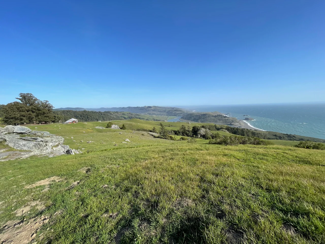 This is coastal prairie descending to Russian River mouth and Pacific Ocean. The view is from The Wildlands Conservancy Jenner Headlands Preserve. The river is a major geographic feature in this region.