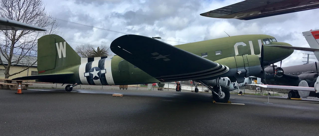 The United States Army Air Forces, the precursor to the United States Air Force, used thousands of special purpose Douglas DC-3 commercial airliners during World War II. Most common was the C-47 “Skytrain” that had a reinforced floor and large cargo door. The similar Douglas C-53 “Skytrooper” carried wounded, cargo, and paratroopers during the war.
This Skytrooper, affectionately known as “Ruby Ann” by her crew, may have flew over Normandy, France, on D-Day on June 6, 1944, doing a glider tow in the first mission of Operation Overlord. That mission started at sunrise on June 6, 1944. It did one addiditional glider tow on June 6 and one more on June 7. She also towed gliders during Operation Market Garden, the largest airborne mission in history. “Ruby Ann” likely dropped supplies to troops surrounded in Bastogne during the Battle of the Bulge, the last major German attack at the end of 1944.
After World War II, “Ruby Ann” came back to the U.S. She first flew as a passenger plane for American Airlines. She passed through several private owners before the Drug Enforcement Agency reclaimed her in July 1984. After two years of restoration, she came to rest here at the Aerospace Museum.