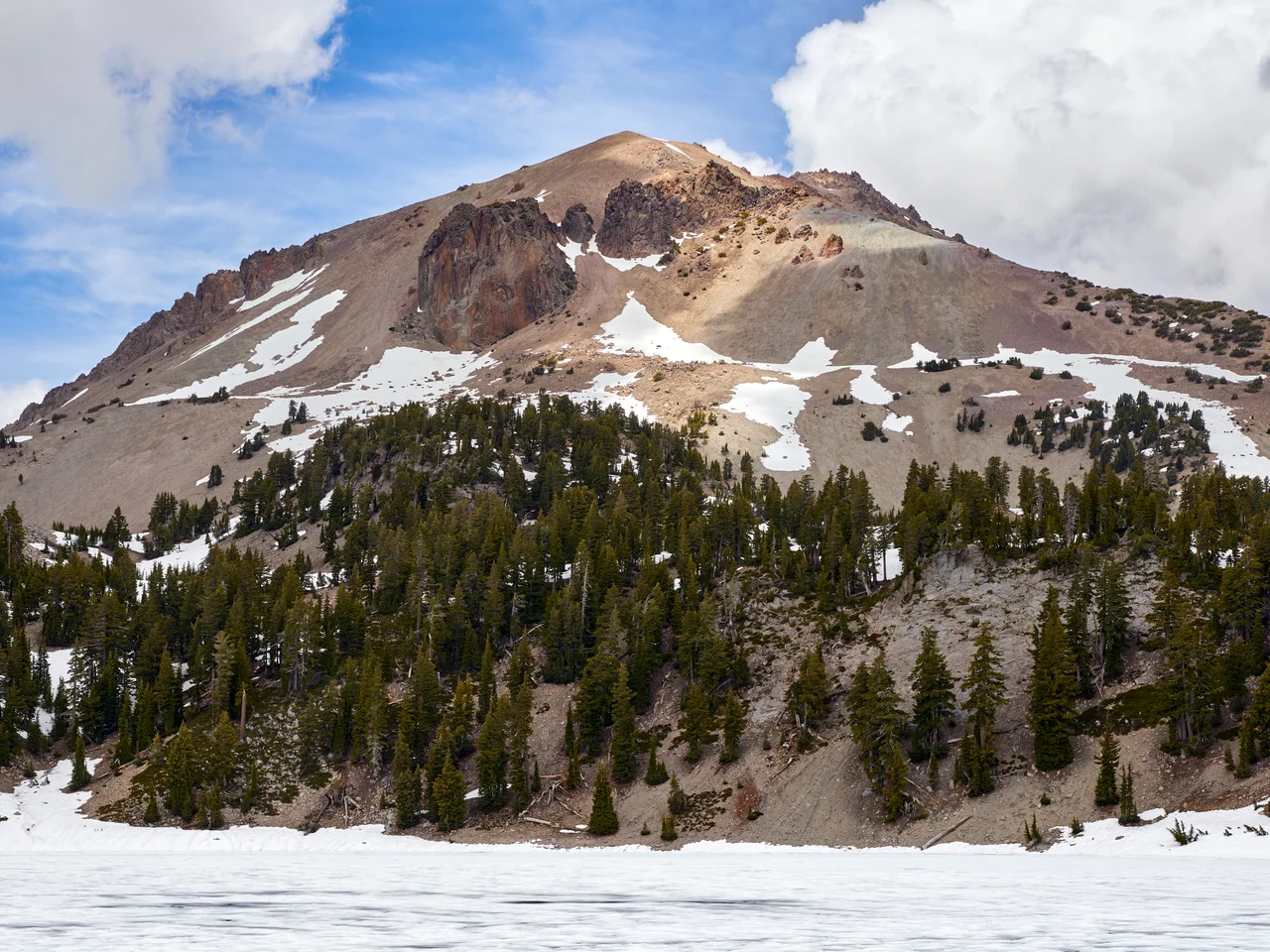Lassen Peak in Lassen Volcanic National Park as seen from the shore of frozen Lake Helen on June 12, 2020.