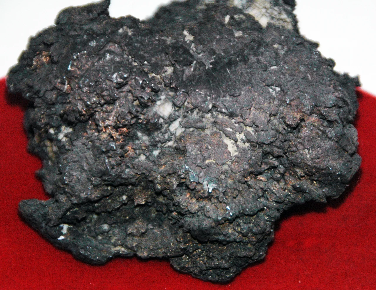 Tarnished native silver from the Tertiary of Colorado, USA. (public display, Leadville Mining Museum, Leadville, Colorado, USA)
A mineral is a naturally-occurring, solid, inorganic, crystalline substrance having a fairly definite chemical composition and having fairly definite physical properties.  At its simplest, a mineral is a naturally-occurring solid chemical.  Currently, there are over 4900 named and described minerals - about 200 of them are common and about 20 of them are very common.  Mineral classification is based on anion chemistry.  Major categories of minerals are: elements, sulfides, oxides, halides, carbonates, sulfates, phosphates, and silicates.
Elements are fundamental substances of matter - matter that is composed of the same types of atoms.  At present, 118 elements are known (four of them are still unnamed).  Of these, 98 occur naturally on Earth (hydrogen to californium).  Most of these occur in rocks &amp; minerals, although some occur in very small, trace amounts.  Only some elements occur in their native elemental state as minerals.
To find a native element in nature, it must be relatively non-reactive and there must be some concentration process.  Metallic, semimetallic (metalloid), and nonmetallic elements are known in their native state as minerals.
Silver is part of the gold-group of metallic elements.  Silver is a precious metal, but is far less valuable than gold or platinum.  Silver usually occurs as a silver sulfide mineral, but it also occurs in nature in its native state, often in the form of twisted wires.  Silver is moderately soft and has a silvery-white color on fresh surfaces that tarnishes to darker colors.  Elemental silver in nature is often found alloyed with other metals.  Naturally alloyed gold-silver is called electrum.
The tarnished silver mass shown above is a 28 ounce silver "nugget" from Colorado's famous Smuggler Union Mine.

Locality: Smuggler-Union Mine, Telluride, San Juan Mountains, Colorado, USA