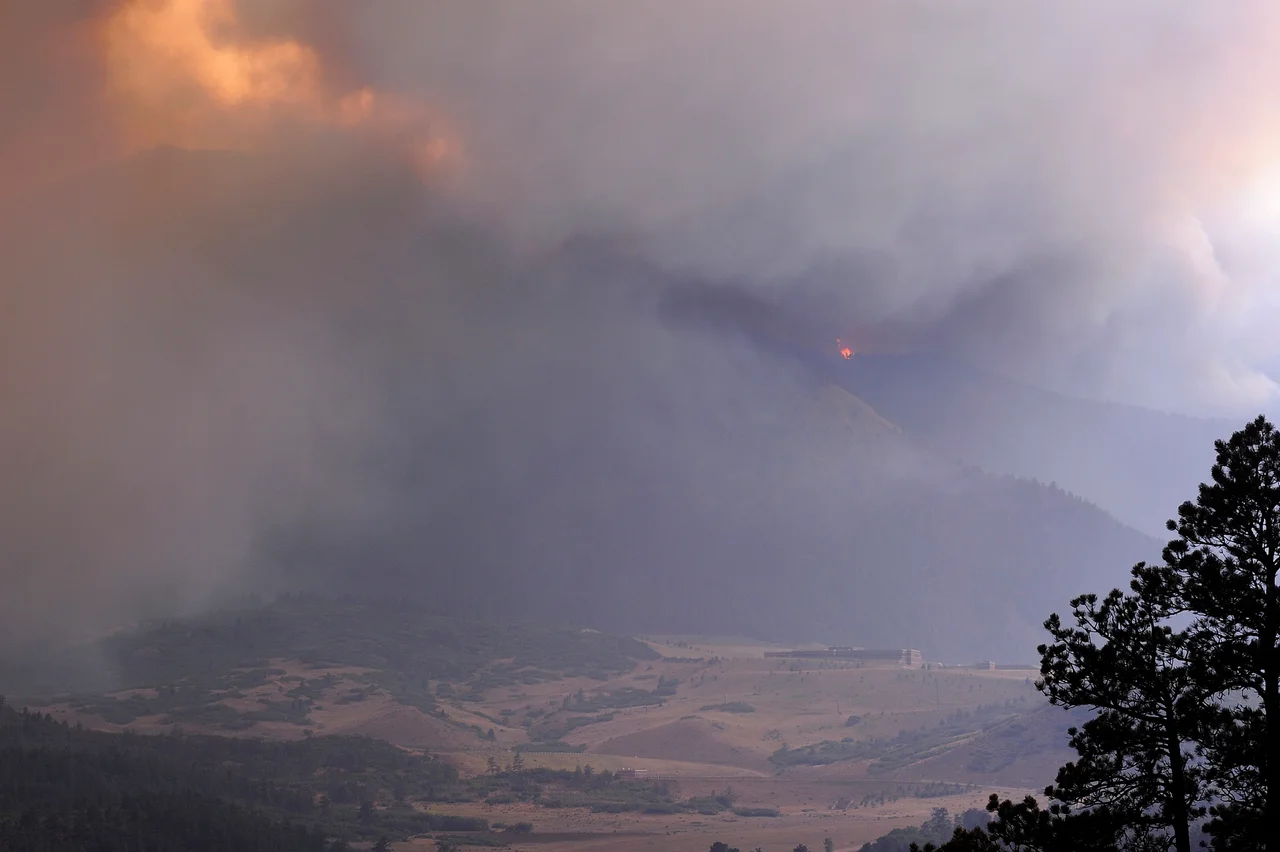 A tremendous smoke cloud builds around the southwest side of U.S. Air Force Academy in Colorado Springs, CO on June 26, 2012. Winds in excess of 65 mph created billowing and rapidly building smoke from the local Waldo Canyon fire. (U.S. Air Force photo/Mike Kaplan)