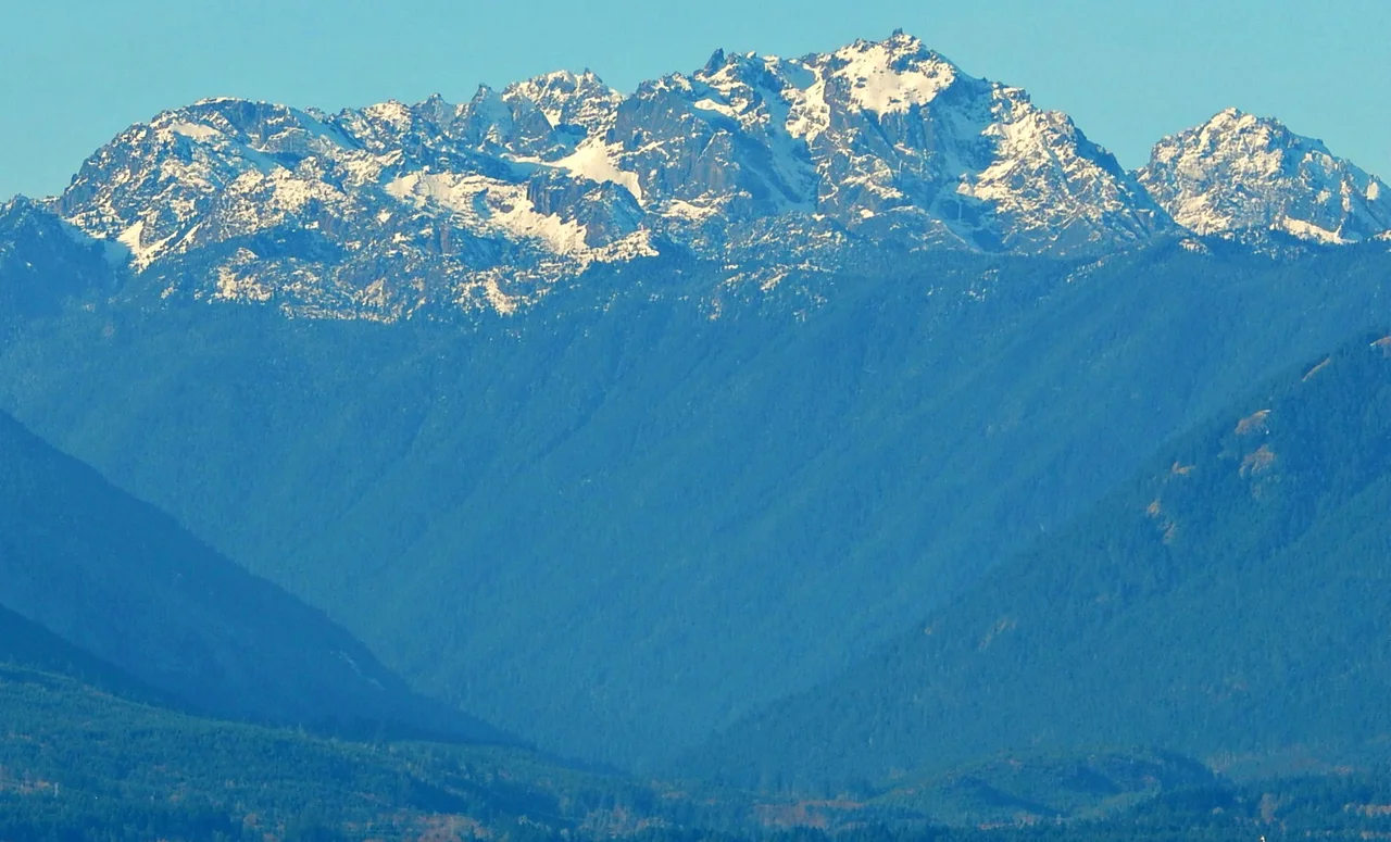 Mount Constance, third highest peak (after Olympus and Deception) in the Olympic mountain range in Washington state. Constance is the highest peak on the Olympic skyline seen from Seattle. This view from Hood Canal.