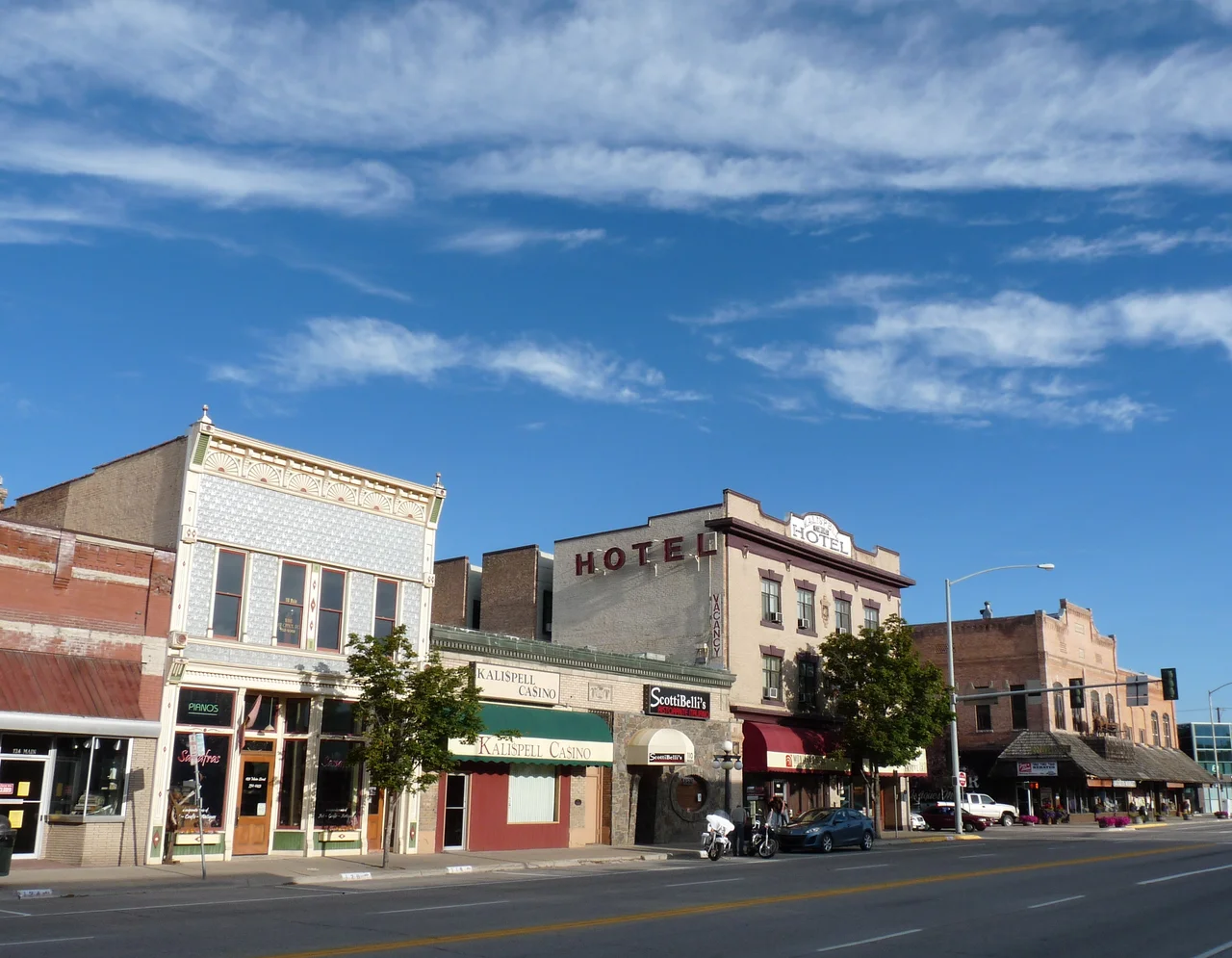 Shown are a few buildings on the Main Street of Kalispell, Montana, USA, including the Brewery Saloon, the Kalispell Grand Hotel, and the McIntosh Opera House. These buildings and others contribute to Kalispell's Main Street Historic District, recognized by the National Register of Historic Places.