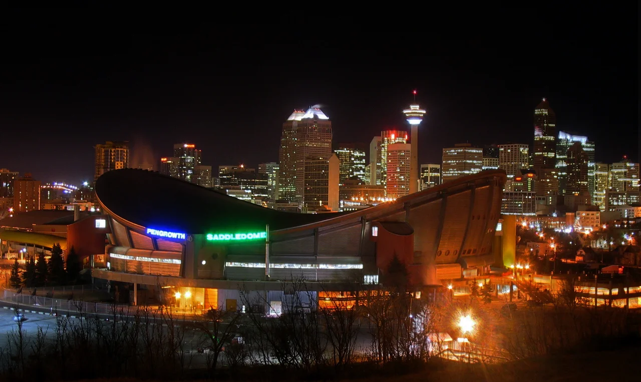 Pengrowth Saddledome &amp; Skyline. The Pengrowth Saddledome at night with the Calgary skyline behind.