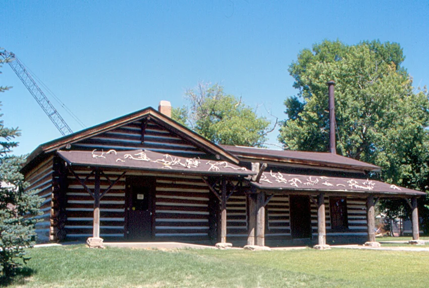 "Charles M. Russell (1864-1926) was a painter of Western scenes of the U.S. These included cownboys and other white settlers, Indians, and landscapes. He created over 2,000 paintings. He lived most of his adult life in Great Falls, Montana. The C. M. Russell Museum has the largest collection of his works.
I believe that the objects on the roof are elk antlers. Russell's home / studio was moved to a location next to the museum."