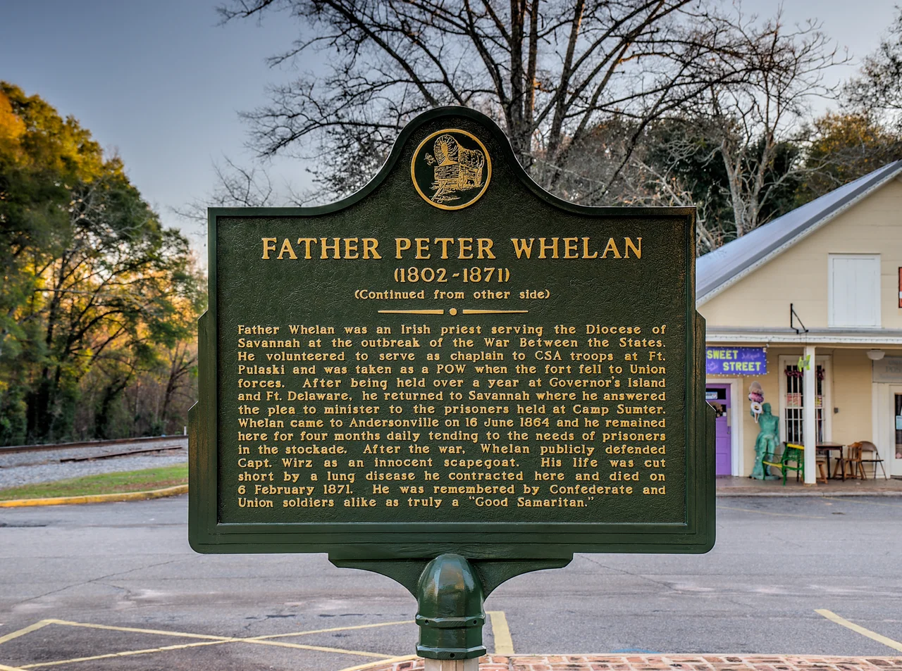 Father Peter Whelan
(1802-1871)
(Continued from other side)
Father Whelan was an Irish priest serving the Diocese of Savannah at the outbreak of the War Between the States. He volunteered to serve as chaplain to CSA troops at Ft. Pulaski and was taken as a POW when the fort fell to Union forces. After being held over a year at Governor's Island and Ft. Delaware, he returned to Savannah where he answered the plea to minister to the prisoners held at Camp Sumter. Whelan came to Andersonville on 16 June 1864 and he remained here for four months daily tending to the needs of prisoners in the stockade. After the war, Whelan publicly defended Capt. Wirz as an innocent scapegoat. His life was cut short by a lung disease he contracted here and died on 6 February 1871. He was remembered by Confederate and Union soldiers alike as truly a "Good Samaritan."