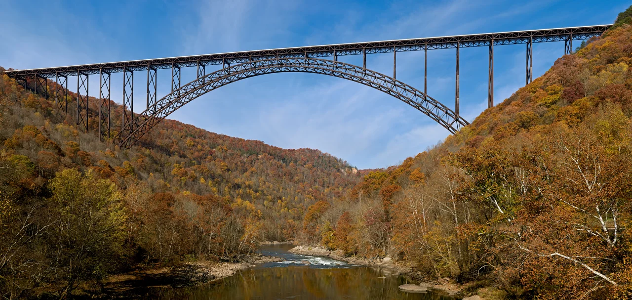 The New River Gorge Bridge in Fayetteville, West Virginia is a steel arch bridge that carries US 19 over the New River. It opened in 1977 and is the longest and highest steel arch bridge in the Western Hemisphere at 3030 ft (924 m) long and 876 ft (267 m) high. The bridge hosts Bridge Day, an annual event in which it closes to vehicles, and participants are allowed to BASE jump to the valley floor below.