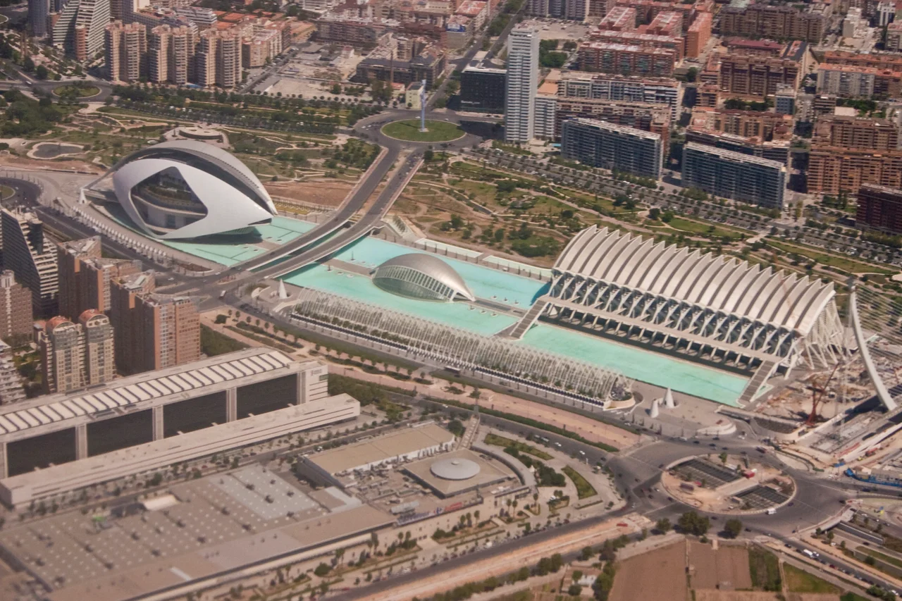 An aerial image taken from a Boeing 737 on the EMA to VLC flight path of The Ciutat de les Arts i les Ciències (Valencian), Ciudad de las Artes y las Ciencias (Spanish) or City of Arts and Sciences. The buildings are situated in the Turia Gardens, a dry river bed of the now diverted River Turia in Valencia, Spain. The image depicts: El Palau de les Arts Reina Sofía (opera house and performing arts centre), L'Hemisfèric (Imax Cinema, Planetarium and Laserium), L'Umbracle (walkway / Garden) and El Museu de les Ciències Príncipe Felipe (science museum). Taken using Canon 300D, ISO 100, 55mm (18-55mm), f/8, 1/1500 sec