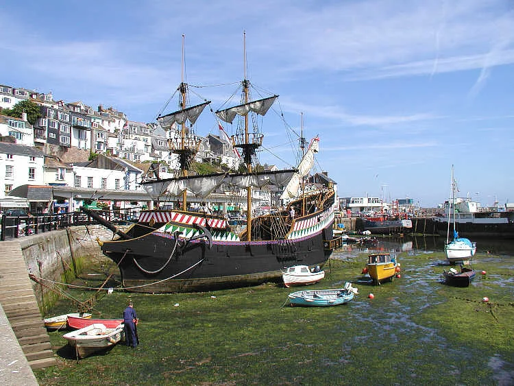 A replica of Sir Francis Drake's ship - the Golden Hind - lying permanently in Brixham Harbour. The original ship, with a crew of 80 sailors and 10 officers, circumnavigated the globe between 1577 and 1580. Five ships set out -  Pelican, Elizabeth, Swan, Marigold and Benedict. During the voyage the Pelican was renamed the Golden Hind in honour of his friend Christopher Hatton whose  crest featured a hind (a deer). Sir Francis brought home looted gold, silver, jewels and cash worth 25 million pounds in today's (2003) money. Only two of the ships returned, the Golden Hind and the Elizabeth. Taken by Adrian Pingstone in July 2003 and released to the public domain.