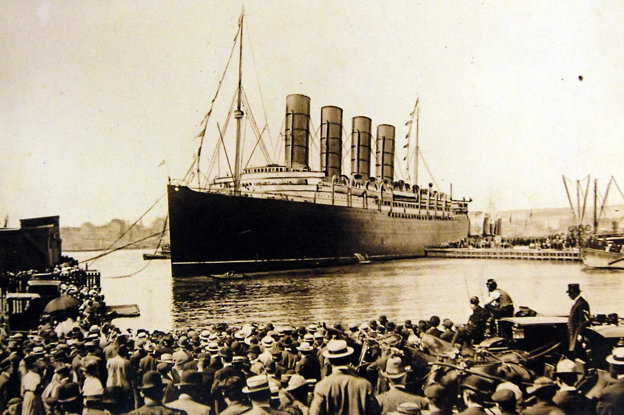Lot-10973-1: RMS Lusitania warping into doc after record breaking run from Queenstown, Ireland, to New York City, New York, September 13, 1907. Thousands crowded the river shores and all the fleet in the New York Harbor tooted shrill welcome when Lusitania arrived after lowering the record from Queenstown to 5 days and 54 minutes. The Lusitania’s sister ship was the Mauretania. George C. Bain Collection. Courtesy of the Library of Congress, also as LC-USZ62-55380. (2016/10/14).