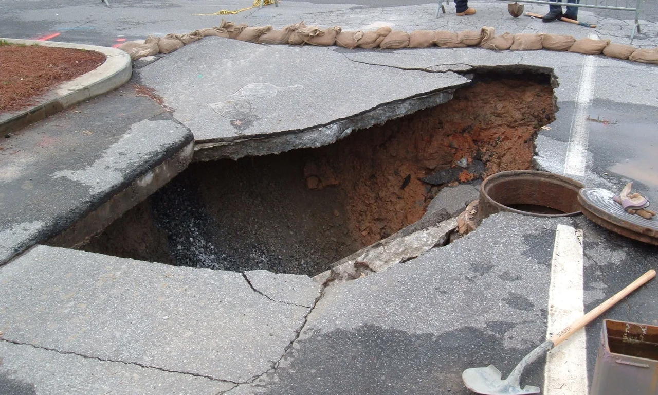 This is a sinkhole in a parking lot at Georgia Tech in Atlanta, GA, USA.
A contractor I spoke with said the hole was 32 feet deep.  It was formed as rainwater leaked through the pavement and into a break in the sewer line below.