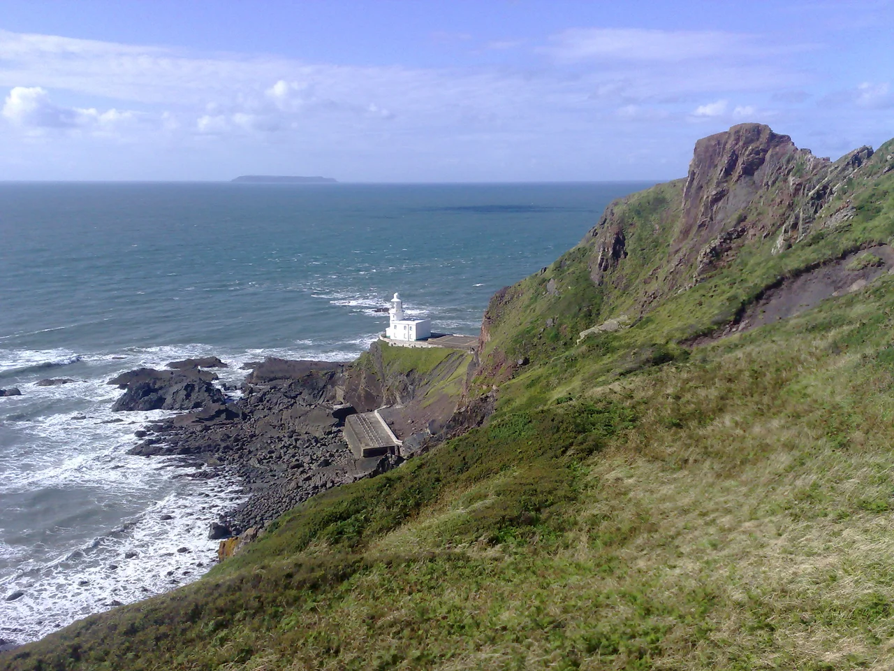 Hartland Point lighthouse, North Devon, England. The island of Lundy is in the distance
