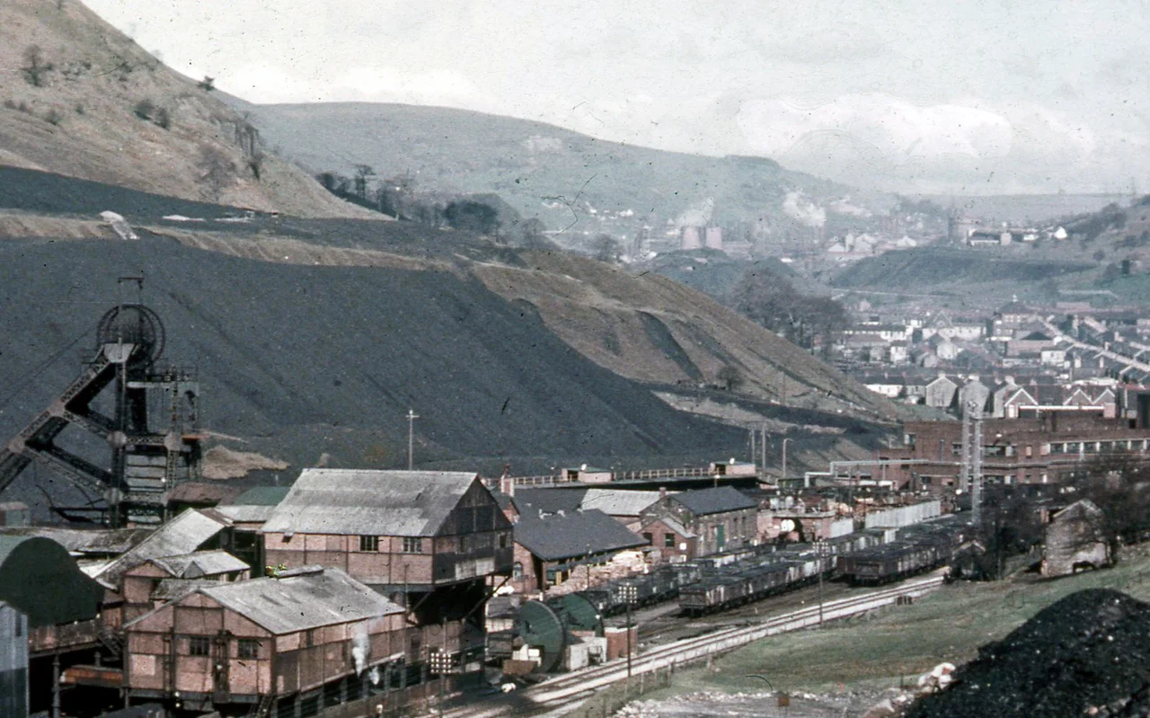 Billet train near Celsa steelworks. A train carrying billets of steel makes its way from Celsa Steelworks to Castle Works, one of several such trains to run each day. The locomotive is No. DH50-2, built by Hunslet.