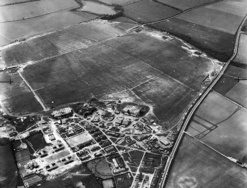 IWM caption: Oblique aerial view of RAF Wittering, Cambridgeshire, showing the technical and domestic sites and airfield looking west from a point over the A1. White Water Lake can be seen at top centre.