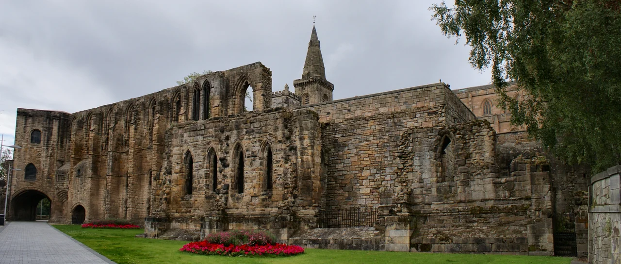 The imposing south wall and gatehouse of Dunfermline Palace. The Abbey can be seen in the background.