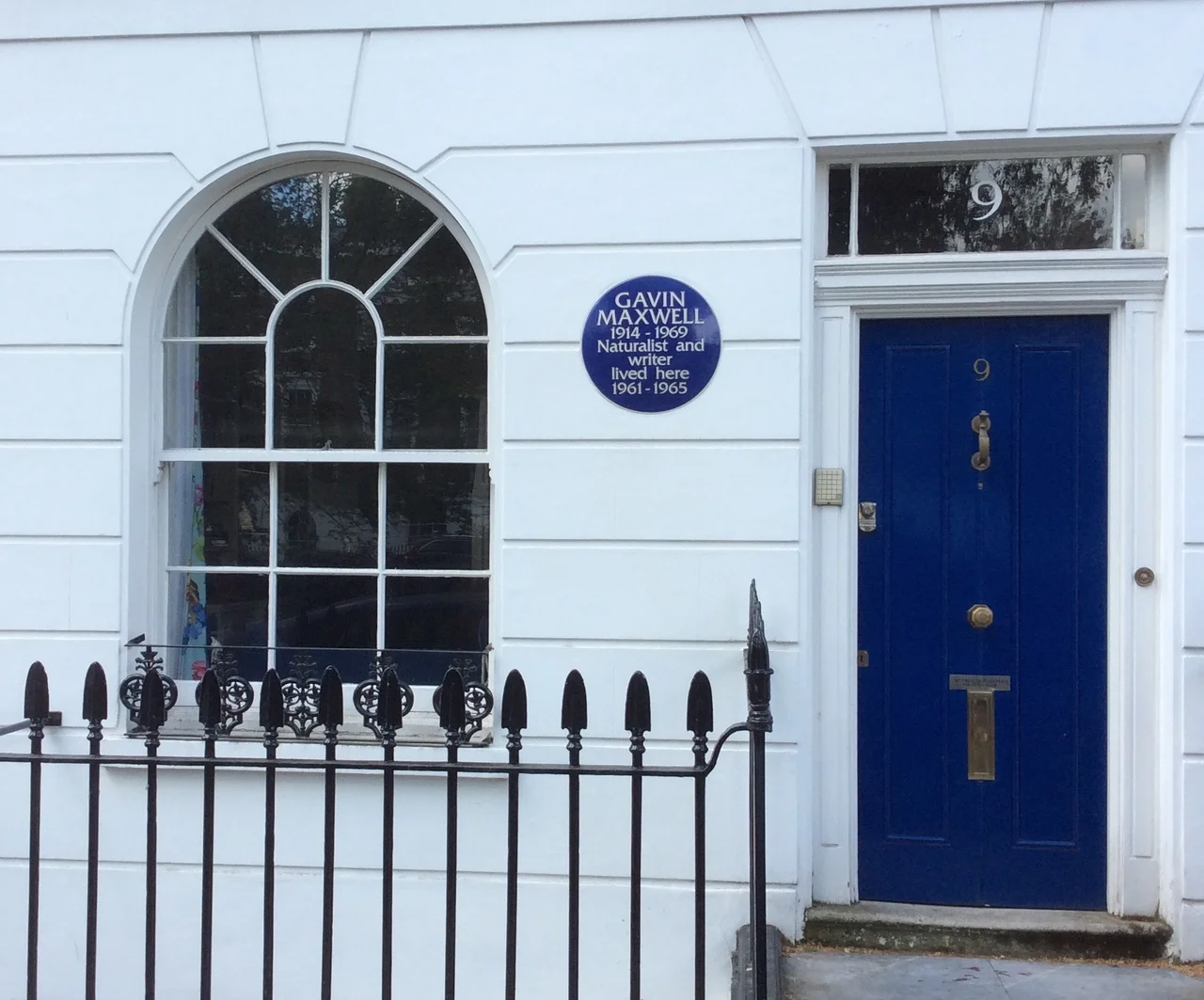 A blue plaque commemorating writer and naturalist Gavin Maxwell at a house where he lived in Paultons Square, London, United Kingdom.
