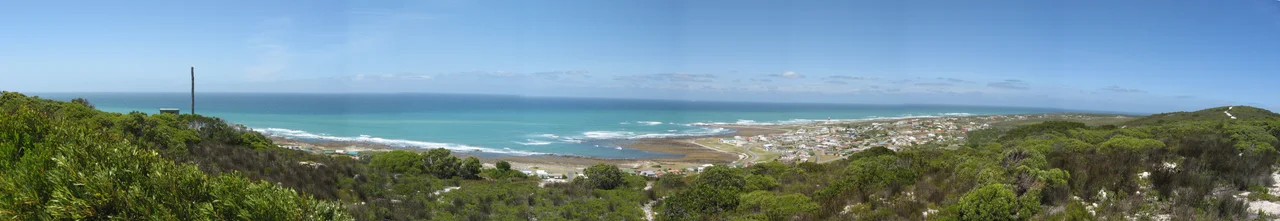 Panorama at Cape Agulhas around the southernmost tip of Africa.  The parking area with the marker for the southernmost point is visible in the near right.  Taken from the lighthouse.