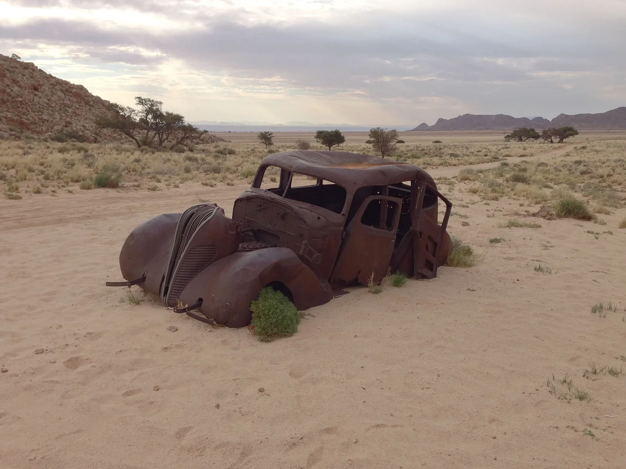 Hudson Terraplane (1937) in Ghost Valley, Aus-Mountains, Namibia. Background: trail of Lüderitzbahn railway, Diamond Area 1, Tsau-ǁkhaeb-Sperrgebiet (Namib desert).