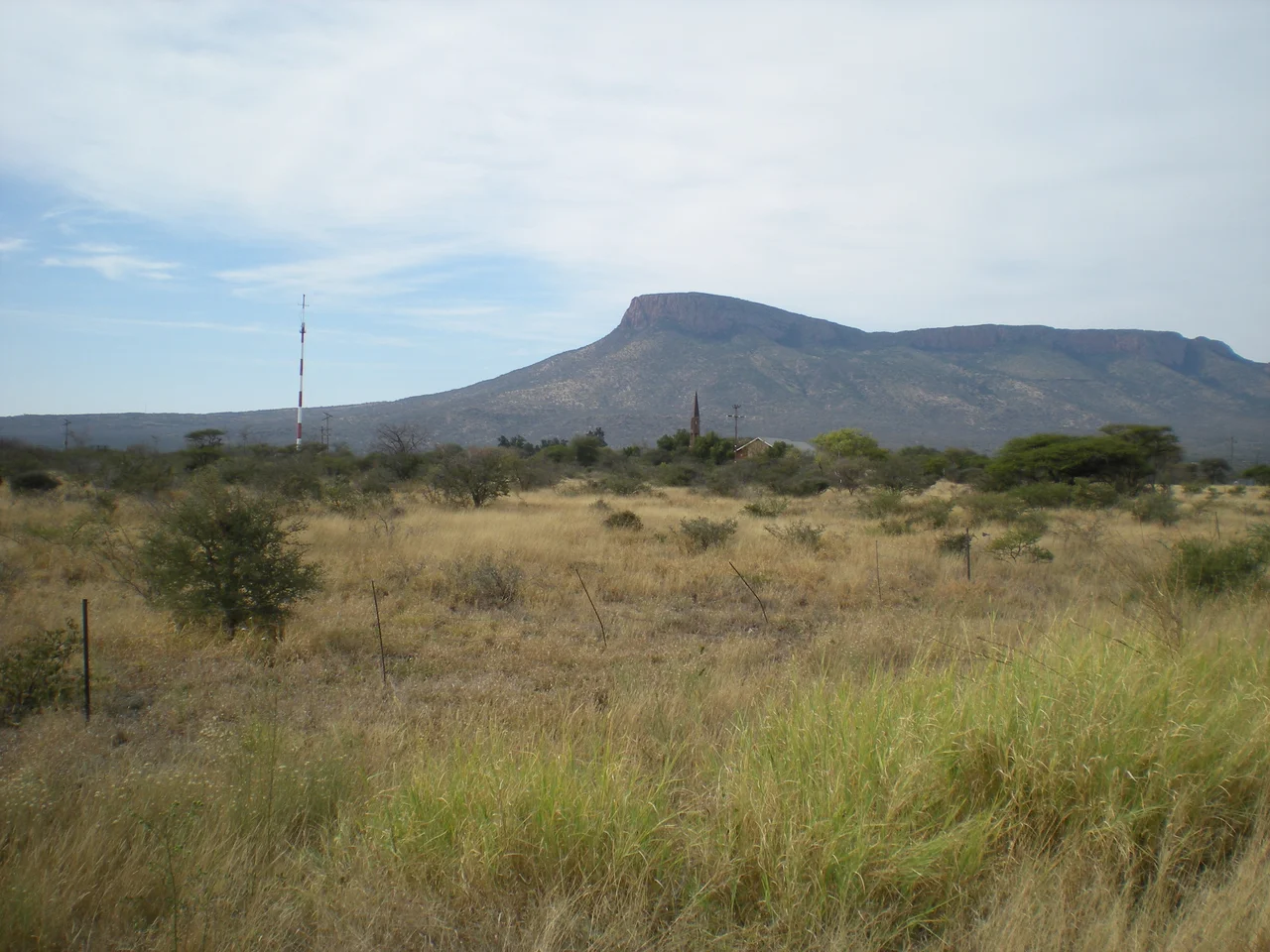 Church steeple in Vivo, Limpopo Province, South Africa. Photograph taken from the road to Schiermonnikoog around noon, Sunday 7 June 2009, close to the main T-junction at the centre of Vivo. The mountains in the background are the western-most peaks of the Soutpansberg.