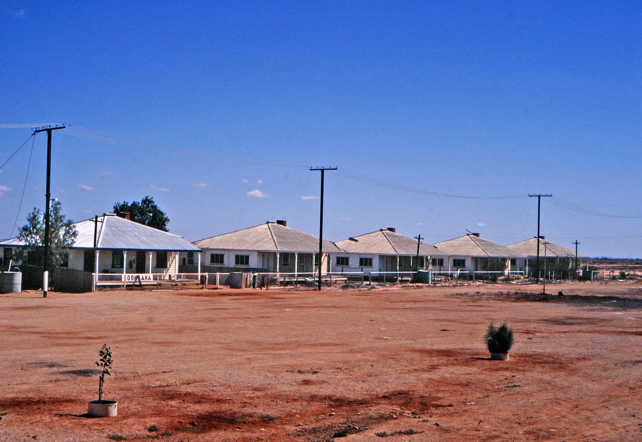 Employee houses of the former Commonwealth Railways at Loongana, Western Australia, 1147.5 km from Port Augusta, South Australia, on the 1693.5 km-long Trans-Australian Railway between Port Augusta and Kalgoorlie. The former settlement is at (approximately) the middle of the Nullarbor Plain and is on the longest length of straight track in the world, 478.193 km long. The railway is part of the 4352 kilometre Sydney–Perth rail corridor. The houses were for employees at a time when it was necessary to have local maintenance crews available; now maintenance is undertaken by contractors who live elsewhere. Since the photo was taken in 2006, all buildings have been demolished or removed from Loongana and many other localities on the Trans-Australian Railway. As of 2021, trains do not stop at Langoona, but there is a triangle for reversing rail vehicles.