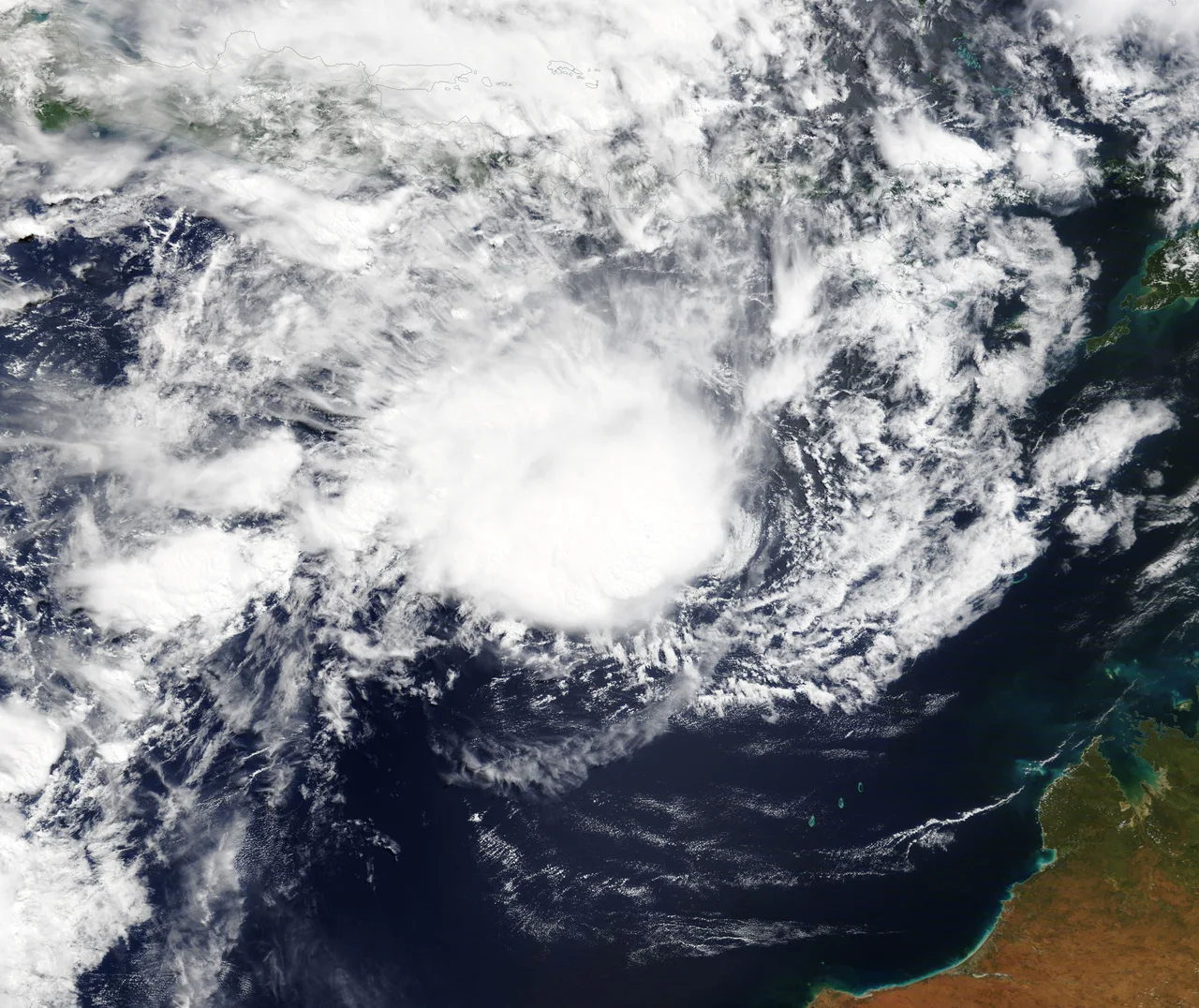 Before the year 2004, only two tropical cyclones had ever been noted in the South Atlantic Basin, and no hurricane. However, a circulation center well off the coast of southern Brazil developed tropical cyclone characteristics and continued to intensify as it moved westward. The system developed an eye and apparently reached hurricane strength on Friday, March 26, before eventually making landfall late on Saturday, March 27, 2004.
The crew of the International Space Station was notified of the cyclone and acquired excellent photographs of the storm just as it made landfall on the southern Brazilian state of Santa Catarina (the storm has been unofficially dubbed “Cyclone Catarina”). Note the clockwise circulation of Southern Hemisphere cyclones, the well-defined banding features, and the eyewall of at least a Category 1 system. The coastline is visible under the clouds in the upper left corner of the image.