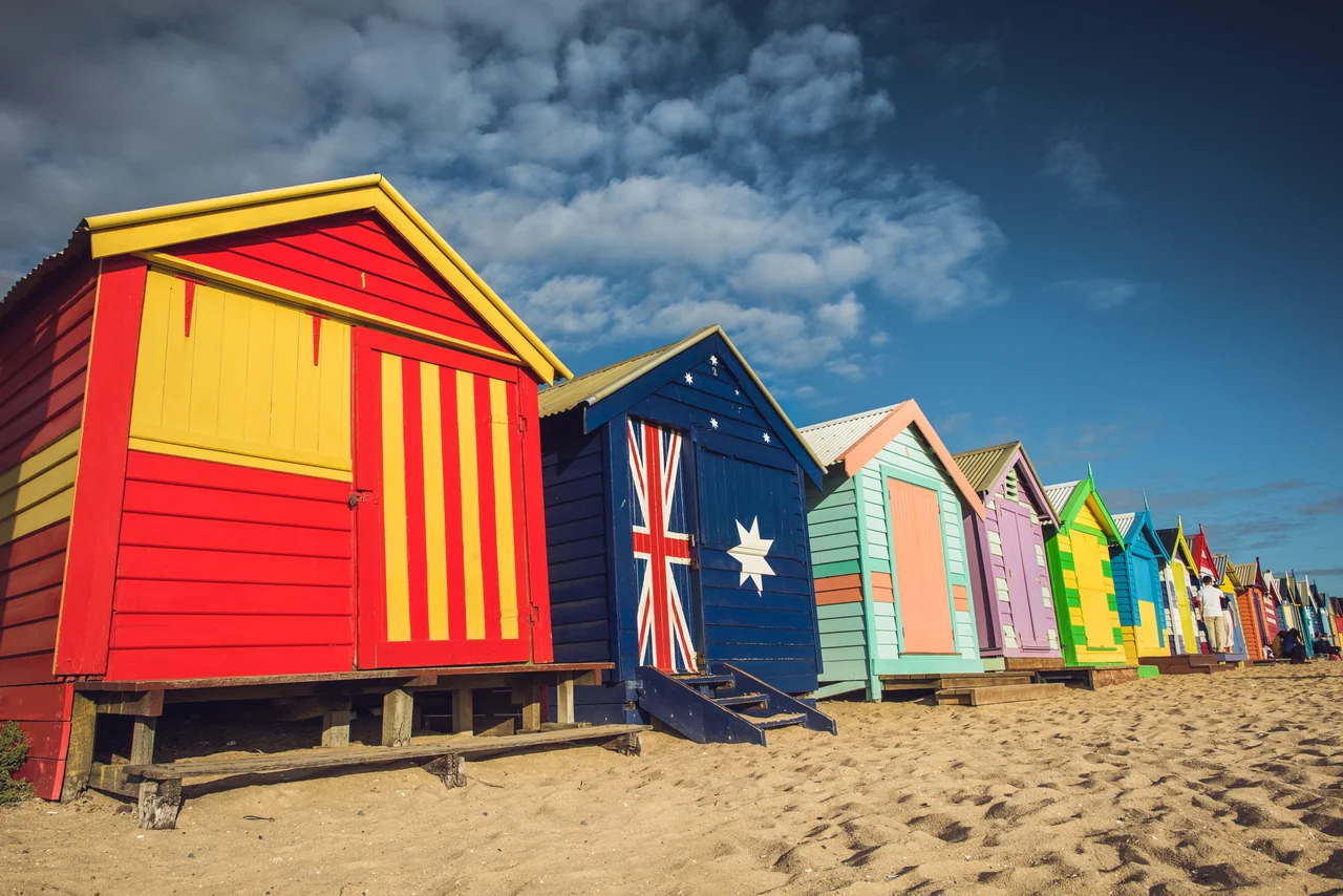 500px provided description: Famous bathing boxes at Brighton beach in Melbourne, Australia. [#sky ,#city ,#color ,#beach ,#light ,#clouds ,#house ,#paint ,#sand ,#melbourne ,#surf ,#colorful ,#flag ,#houses ,#boxes ,#brighton ,#continent ,#aboriginal ,#oz ,#Australia]