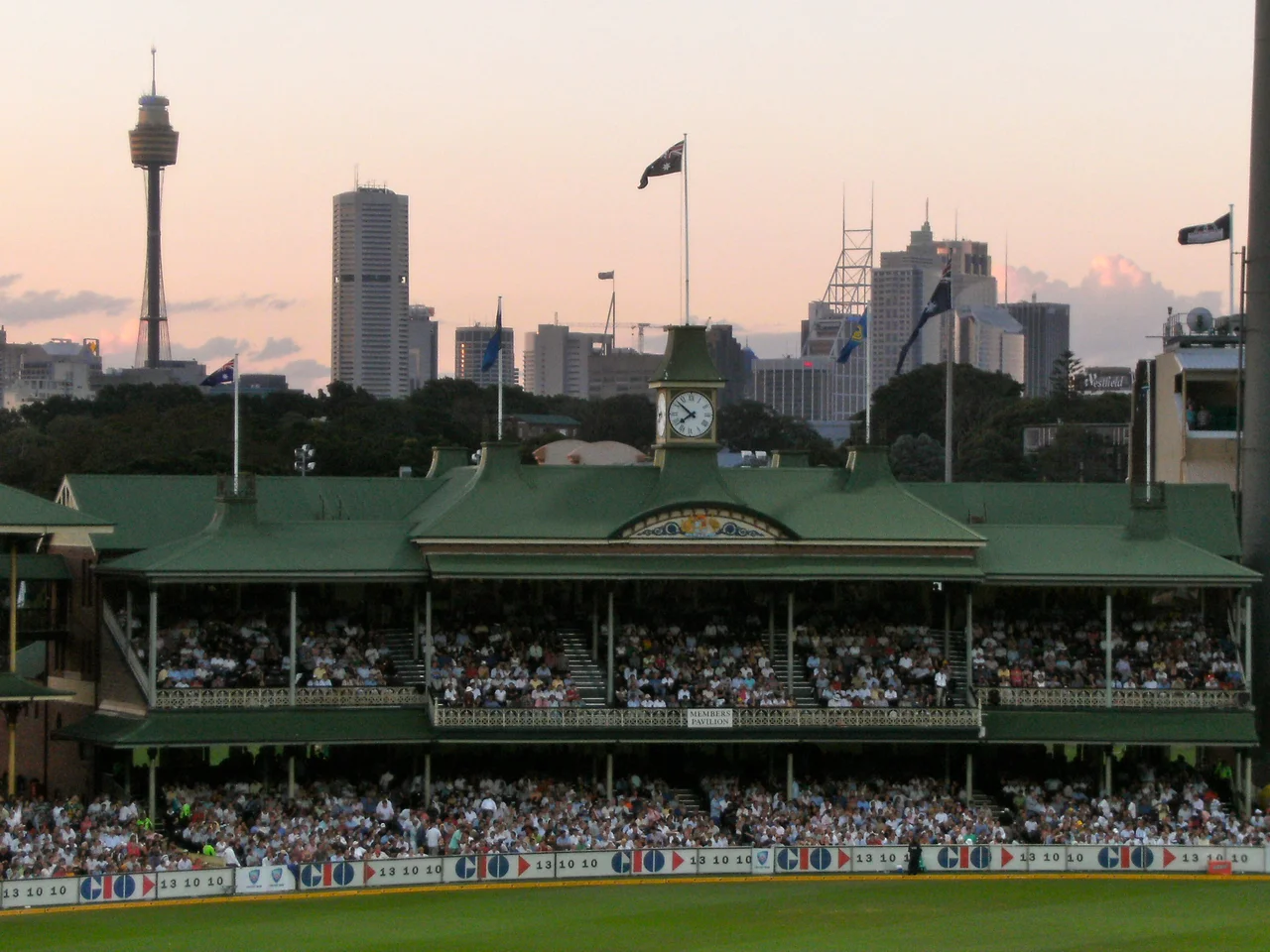 The historic Members' Pavilion under lights with the Sydney skyline behind