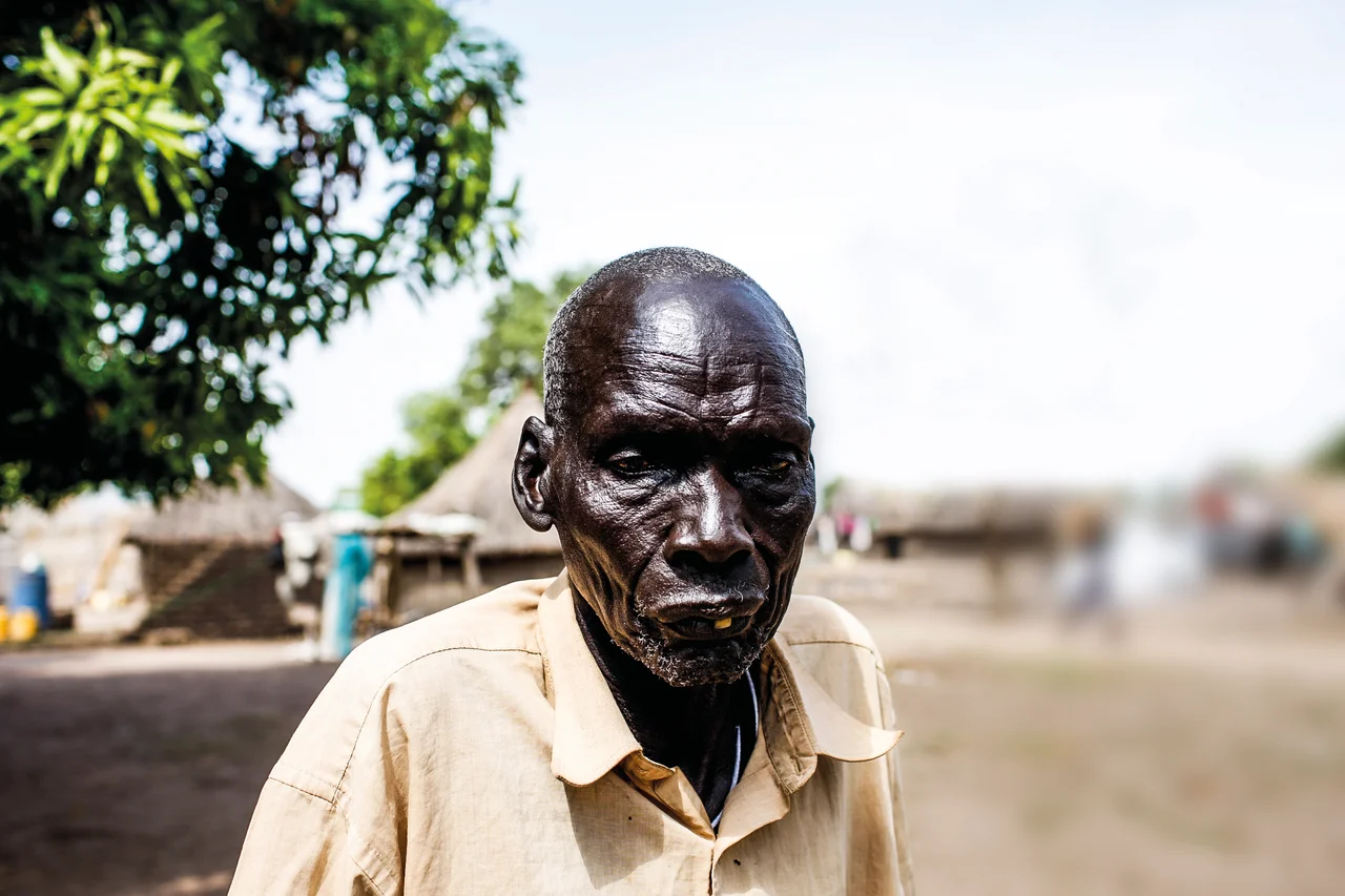 I have lived many years and know how we lived before all the wars. We were cattle keepers and could move freely grazing our bulls. Yes, there were clashes and fights like in every society, but they were small and could be resolved with time and reason. There were traditional systems that worked. We were free to travel and see different lands, meet new people and share our experiences, all the while trading in cattle and making money. This has not been the reality for a long time.
I was in Bor with my family when the fighting broke out. I told them to run because I am old and disabled. I lost my leg during the first war. I was left alone and on the first day, men walked into my house. They were Nuer. One of them saw me and wanted to kill me but his friend stopped him in his tracks.
He looked at the young man and asked, ‘Look at this man. If you kill him, what will you accomplish? This man has done nothing wrong to you and yet you want to kill him. What will you gain from doing that?’
The young man lowered his gun and left the house. I don’t know the name of the man who saved my life but I am very grateful for what he did. Before he left, he looked at me and said, ‘Stay here and don’t make any noise. I will lock the door behind me. Do not open it for anyone else.’
That man saved my life. I wish I knew his name and where to find him so that I can thank him again.
‘He gives me hope that there is still room for healing despite all wounds we have endured.
There is still hope if our systems transform towards reconciliation and healing.’
Photo: Mackenzie Knowles Coursin/Oxfam