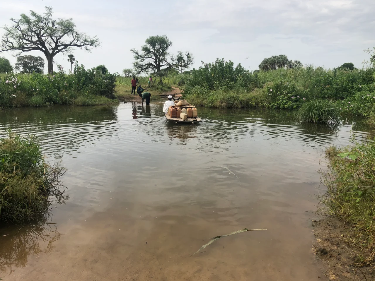 A villager in Darfur, Sudan, crosses the overflowing stream.