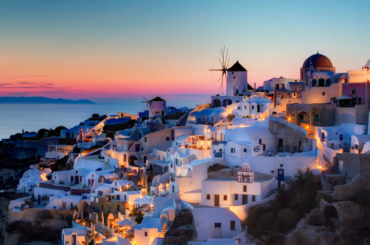 Sunset in Oia, Santorini.
Here is my version of the sunset shot in Oia. This is a blend of 3 shots, 1.3 to 20 seconds, processed as follows:
1) Reduce noice on all 3 raws.
2) Create HRD in Photomatix
3) Blend using Exposure Fusion, sliders set to produce the most natural looking image while still showing some detail in the very dark areas.
4) PS smart sharpen.
5) PS burn the bottom
6) Nik Brilliance and warming
7) Nik Indian summer to warm th elights, masked to not affect the rest.
8) Nik sunlight, brushed over the buildings to add more light
9) Nik Glamour Glow to remove detail in the dark areas.
10) Detailed curves lightening pn windmills.
11) Dodge buildings that were too dark.