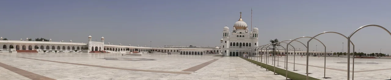 Gurdwara Sri Darbar Sahib or Gurdwara Darbar Sahib Kartarpur, also called Kartarpur Sahib, is a Gurdwara in Kartarpur, located in Shakargarh, Narowal, Punjab, Pakistan.
Quote by Guru Nanak: "Speak only that which will bring you honor".
The Kartarpur Corridor is known as the corridor of ‘international peace & harmony’ is a 4.2-km-long passage connecting the town of Dera Baba Nanak in India with the Kartarpur Sahib Gurdwara in Pakistan.
Facts
1. Opened by PM. Imran Khan on 09 Nov 2019, just days before the 550th birth anniversary of Guru Nanak. This historic moment officially allowed Indian Sikh pilgrims rare visa-free access to the site.
2. The Congregation is notable for its location. The Shrine is visible from the Indian border. Indian Sikhs gather in large numbers to perform darshan (sacred viewing) of the site.
3. It is also claimed to be the largest Gurdwara in the world & the second holiest site of the Sikh Religion. Guru Nanak (founder of Sikhism, & the first Guru) built town by Ravi River in 1515, plowing the fields & setting up a Sikh community kitchen, or Langar, after his missionary travels & lived for 18 years until his death on 22 September 1539. The Gurdwara is built where Guru Nanak is said to have died.
4. He gave the three principles of Kirat Karo, Naam Japo, Wand Chako, which means work hard for a livelihood, keep remembering the God & share your bounties with the world. Guru's teachings have been peace, harmony & universal brotherhood. He believed in equality between castes, religions & genders.
5. The main Building was built in 1925 at a cost of Rs.1,35,600/- donated by Sardar Bhupindar Singh, the Maharaja of Patiala. It was further expanded in Nov 2018 with the construction of a new courtyard, museum, library, dormitories & locker rooms spread across an area of 42 acres (17 hectares). There is a 20-foot well, which is 500 years old & believed to have been built during the lifetime of Guru Nanak Dev.