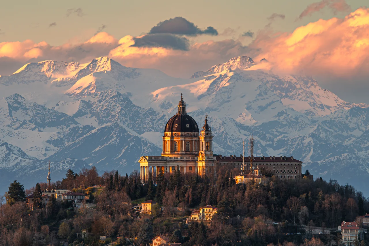 The Basilica of Superga and the Monte Rosa massif in the background at sunset. This hilltop basilica is located in the vicinity of Turin, Piedmont, Italy. The church was built from 1717 to 1731 for Victor Amadeus II of Savoy. It is the traditional burial place of members of the House of Savoy.
