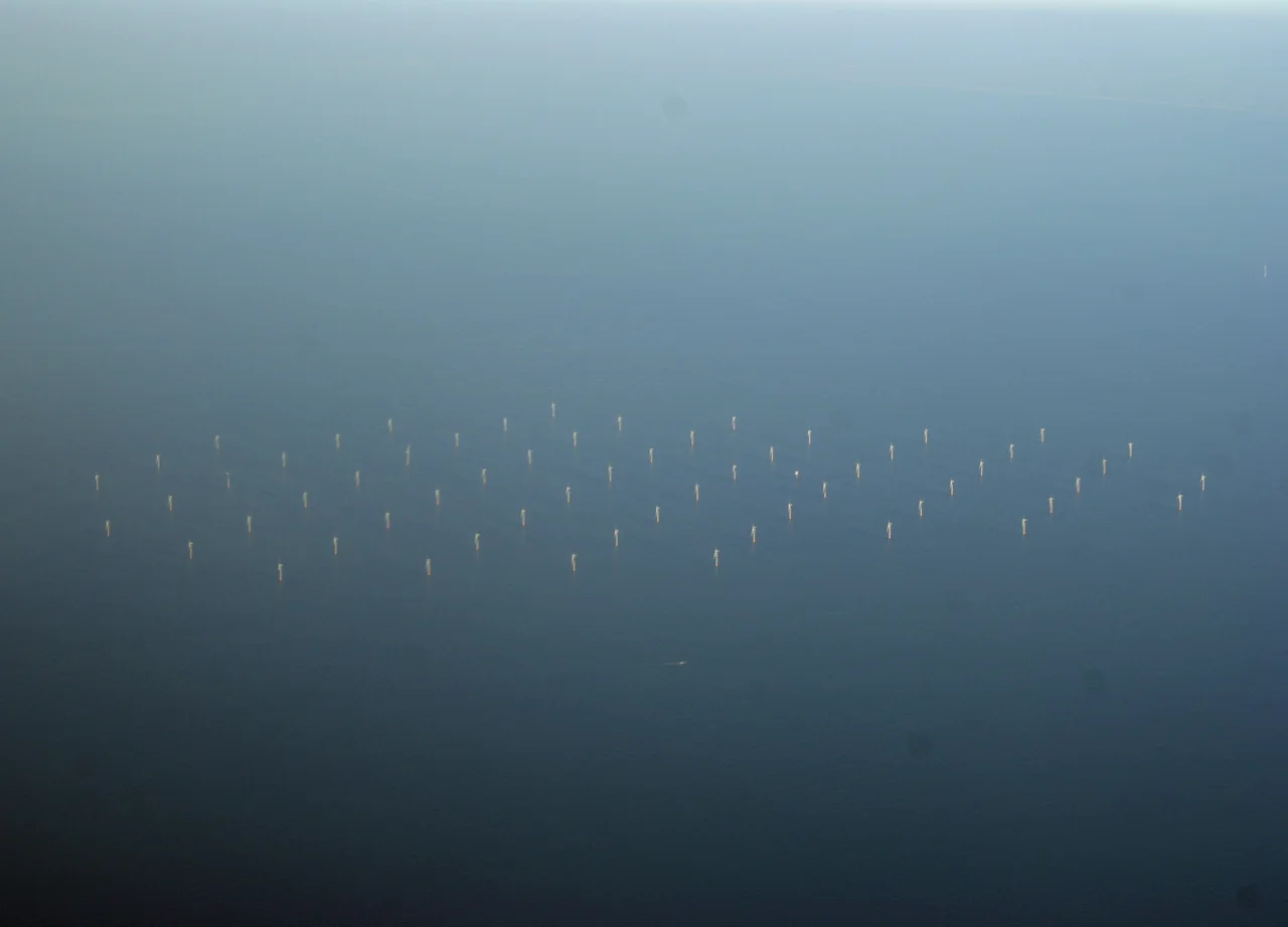 Photo of (presumably) Princess Amalia wind farm in the North Sea, 23 km from IJmuiden. Taken from a plane flying from BHX to AMS. I auto stretched the contrast in the Gimp. I assume it's the Princess Amalia wind farm, since the other wind farm in the vicinity (OWEZ) has 36 turbines whereas the one picture has 60.