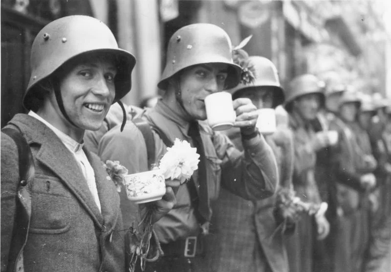 For documentary purposes the German Federal Archive often retained the original image captions, which may be erroneous, biased, obsolete or politically extreme. Einmarsch in das Sudetenland. Die Männer des sudetendeutschen Freikorps bekommen von der Bevölkerung Erfrischungen.
Members of the Sudeten-German Voluntary Corps are served refreshments by the population.
3.10.1938
9.00 Uhr

Eger. Sudetenland