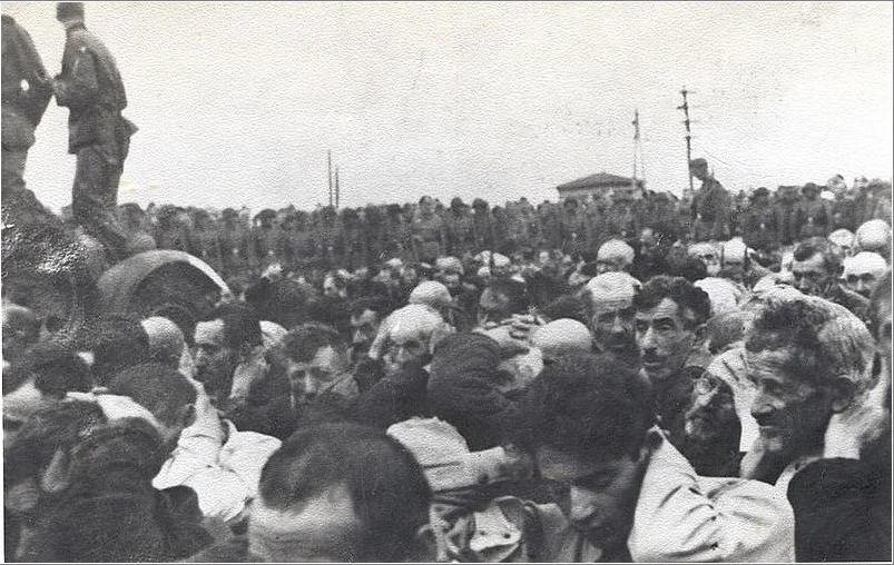 Liquidation of the Białystok Ghetto, 15–20 August 1943. Jewish men with their hands up, watched by a German military unit.