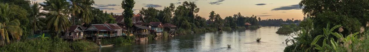 Dwellings and pirogues on the Mekong bank of Don Det at sunrise, seen from the bridge to Don Khon, Si Phan Don, Laos.