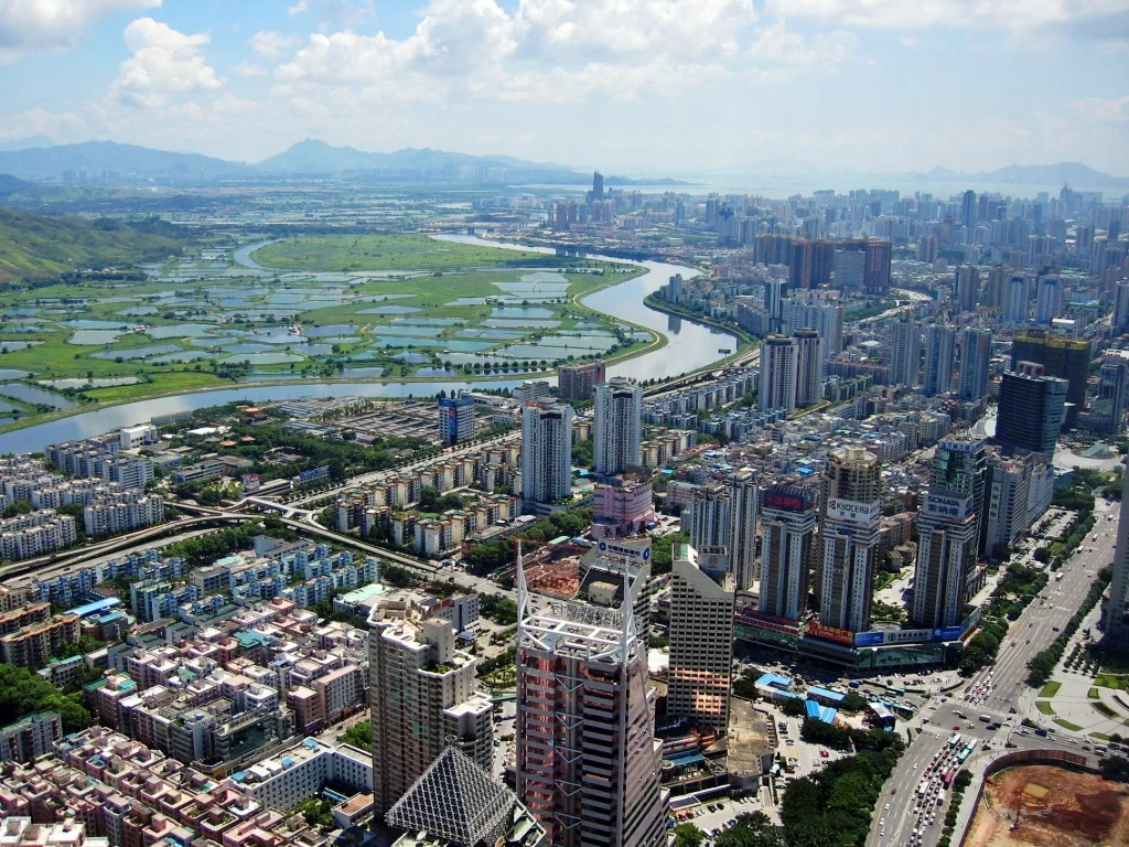 Picture of the western side of the CBD of Shenzhen, China, looking southwest. The Shenzhen River and rice fields can be seen in the background.