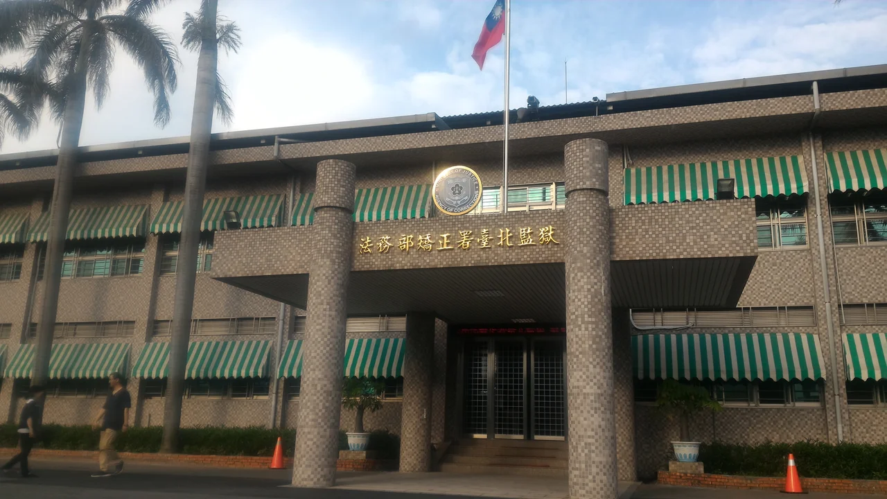 法務部矯正署臺北監獄大門,上方旗桿升起中華民國國旗。