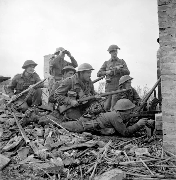 Lieutenant I. Macdonald (with binoculars) of The 48th Highlanders of Canada preparing to give the order to attack to infantrymen of his platoon, San Leonardo di Ortona, Italy. Infantrymen L-R: Sergeant J.T. Cooney, Privates A.R. Downie, O.E. Bernier, G.R. Young, Corporal T. Fereday and Private S.L. Hart.